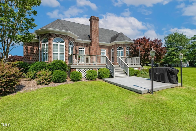 206 W Stoneybrook Ct, Benson, NC 27504 - rear view of house with brick siding, a wooden deck, a yard, a chimney, and roof with shingles