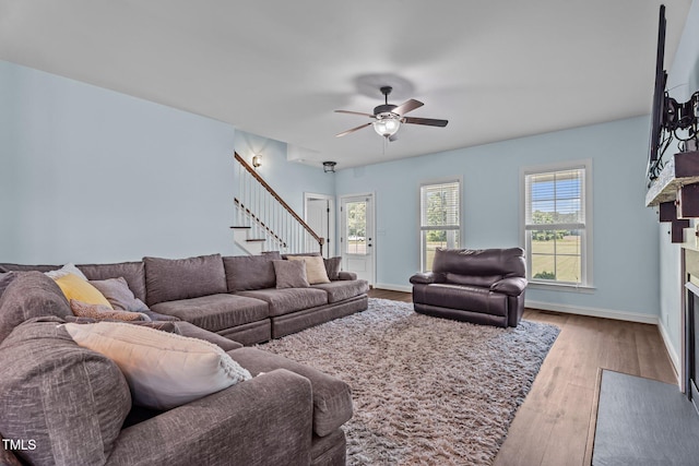 4333 US-117 Hwy, Wilson, NC 27893 - living area with wood finished floors, a fireplace with flush hearth, stairway, ceiling fan, and baseboards
