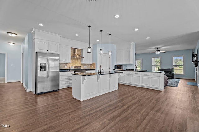 4333 US-117 Hwy, Wilson, NC 27893 - kitchen featuring stainless steel appliances, wall chimney range hood, dark countertops, open floor plan, and dark wood-style flooring