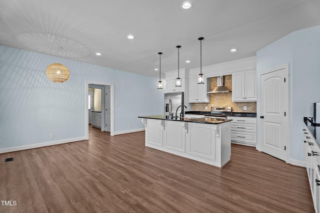 4333 US-117 Hwy, Wilson, NC 27893 - kitchen with appliances with stainless steel finishes, dark countertops, baseboards, dark wood-style flooring, and wall chimney exhaust hood