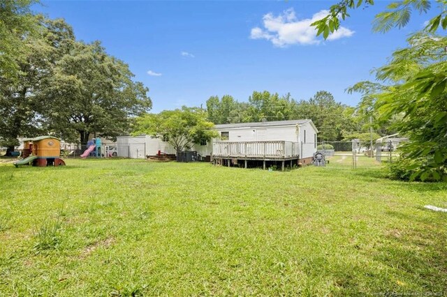 566 Quail Run Rd, Lumberton, NC 28358 - view of yard with a playground, a deck, and view of wooded area
