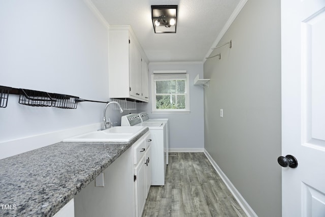 409 Glaive Dr, Durham, NC 27703 - laundry area featuring washing machine and clothes dryer, cabinet space, crown molding, and light wood-style floors