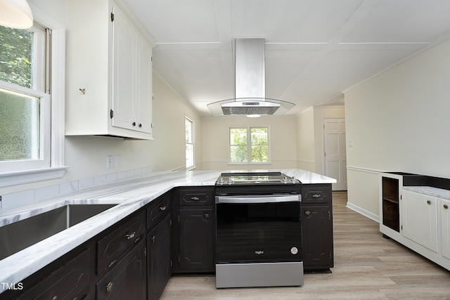 409 Glaive Dr, Durham, NC 27703 - kitchen with stainless steel electric range, island range hood, white cabinets, light wood finished floors, and a peninsula