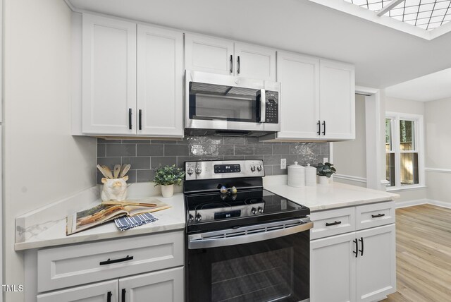 107 Wimbledon Ct, Cary, NC 27511 - kitchen with stainless steel appliances, white cabinetry, decorative backsplash, light wood-style floors, and light countertops