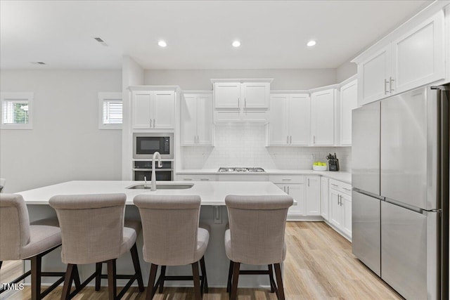 857 Whistable Ave, Wake Forest, NC 27587 - kitchen with freestanding refrigerator, a sink, built in microwave, gas cooktop, and a kitchen island with sink