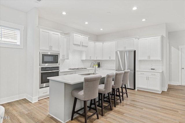 857 Whistable Ave, Wake Forest, NC 27587 - kitchen featuring stainless steel appliances, a sink, an island with sink, white cabinetry, and light countertops