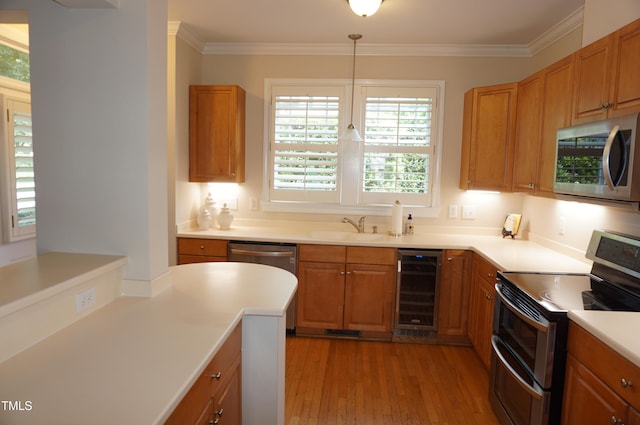 4810 Glenmist Ct, Raleigh, NC 27612 - kitchen featuring appliances with stainless steel finishes, beverage cooler, a sink, crown molding, and light wood-style floors