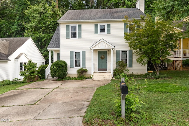 713 Saint Catherines Dr, Wake Forest, NC 27587 - colonial house featuring a front yard, a chimney, a shingled roof, and driveway