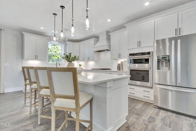 1100 Balsawood Dr Unit 5, Durham, NC 27705 - kitchen featuring stainless steel appliances, custom exhaust hood, a center island, backsplash, and light countertops