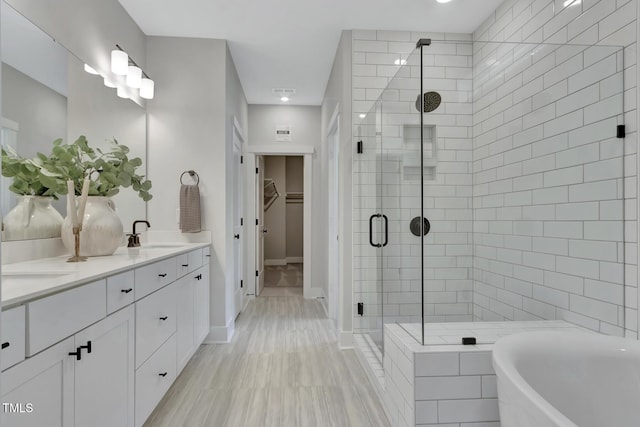 1100 Balsawood Dr Unit 5, Durham, NC 27705 - full bathroom featuring a shower stall, a walk in closet, double vanity, a freestanding tub, and baseboards