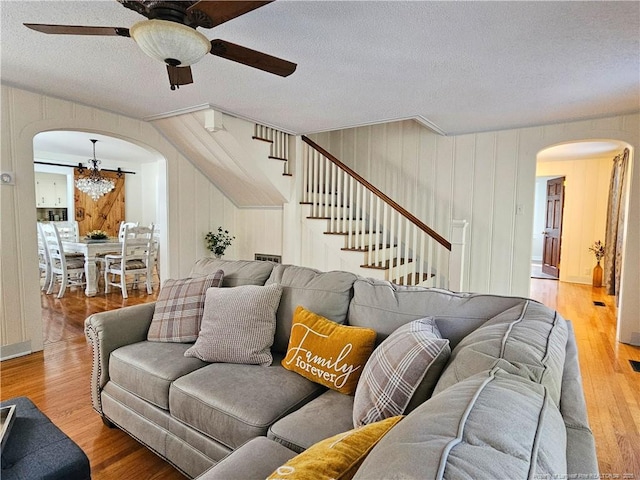 3647 Olivia Rd, Sanford, NC 27332 - living room with arched walkways, ceiling fan, stairs, wood finished floors, and a textured ceiling