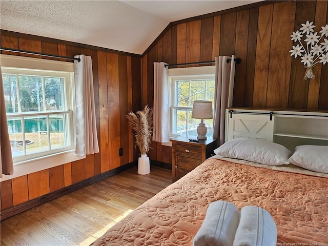 3647 Olivia Rd, Sanford, NC 27332 - bedroom featuring vaulted ceiling, wood finished floors, multiple windows, wooden walls, and baseboards