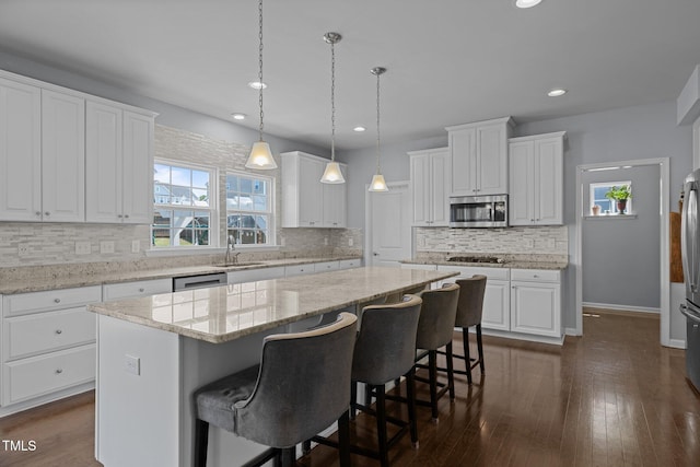 204 Ashland Hill Dr, Holly Springs, NC 27540 - kitchen featuring stainless steel microwave, a kitchen island, recessed lighting, white cabinetry, and decorative backsplash
