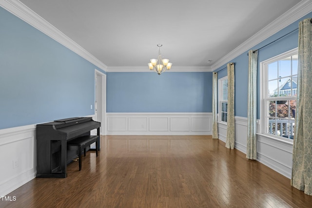204 Ashland Hill Dr, Holly Springs, NC 27540 - unfurnished dining area featuring a chandelier, wood finished floors, ornamental molding, a wainscoted wall, and a decorative wall