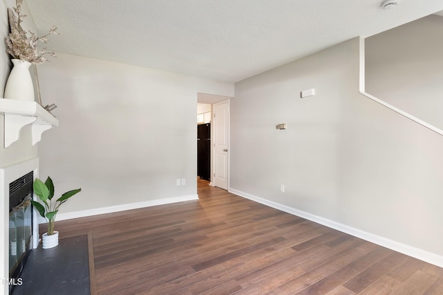 118 Rhum Pl, Garner, NC 27529 - unfurnished living room featuring wood finished floors, a fireplace, baseboards, and a textured ceiling