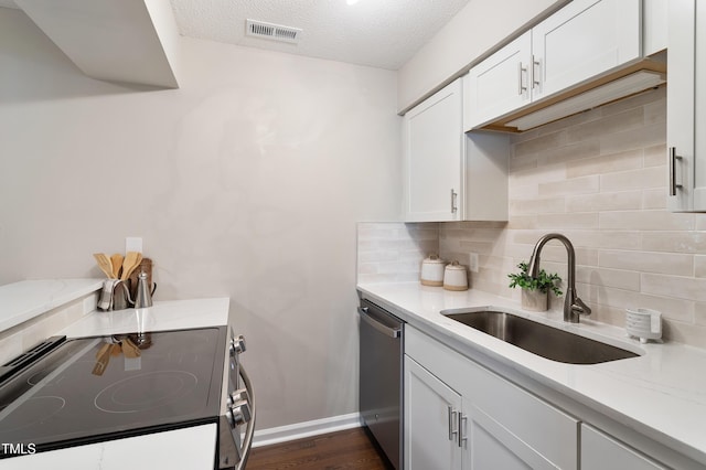 118 Rhum Pl, Garner, NC 27529 - kitchen with stainless steel appliances, a sink, tasteful backsplash, white cabinetry, and a textured ceiling