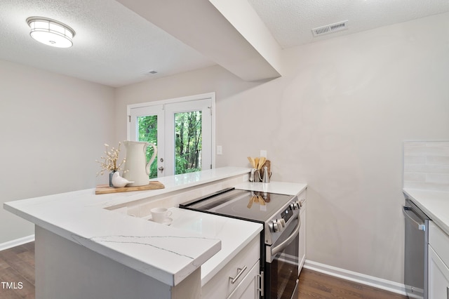 118 Rhum Pl, Garner, NC 27529 - kitchen with electric stove, a peninsula, dark wood finished floors, a textured ceiling, and stainless steel dishwasher