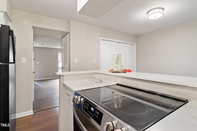118 Rhum Pl, Garner, NC 27529 - kitchen with stainless steel electric range, freestanding refrigerator, dark wood finished floors, white cabinetry, and a textured ceiling