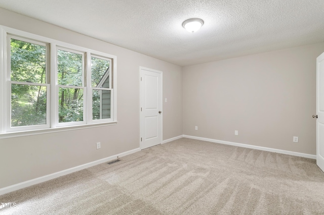 118 Rhum Pl, Garner, NC 27529 - empty room featuring a textured ceiling, light colored carpet, and baseboards