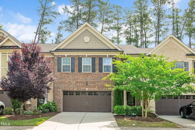 329 Castle Rock Ln, Cary, NC 27519 - view of front facade featuring concrete driveway, brick siding, a garage, and roof with shingles
