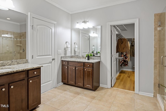 329 Castle Rock Ln, Cary, NC 27519 - bathroom with a stall shower, two vanities, ornamental molding, a spacious closet, and tile patterned floors