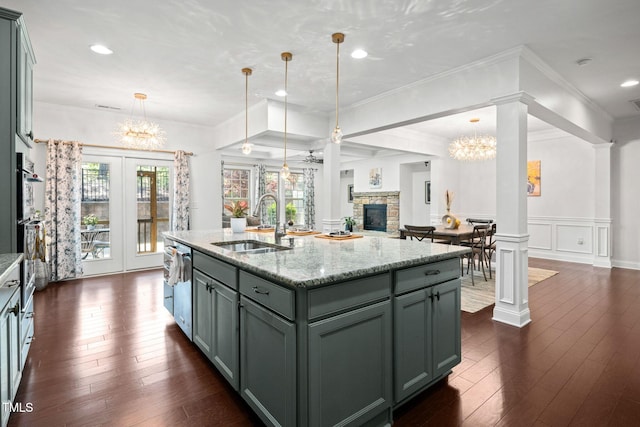 329 Castle Rock Ln, Cary, NC 27519 - kitchen with a chandelier, dark wood-type flooring, open floor plan, light stone countertops, and wainscoting