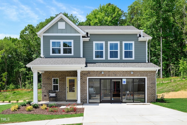 134 Beacon Dr, Pittsboro, NC 27312 - view of front of home with driveway, a porch, brick siding, and a shingled roof