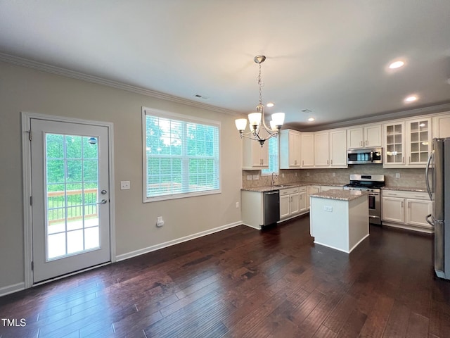 1746 Hammocks Beach Trl, Apex, NC 27502 - kitchen with stainless steel appliances, a sink, a chandelier, crown molding, and plenty of natural light