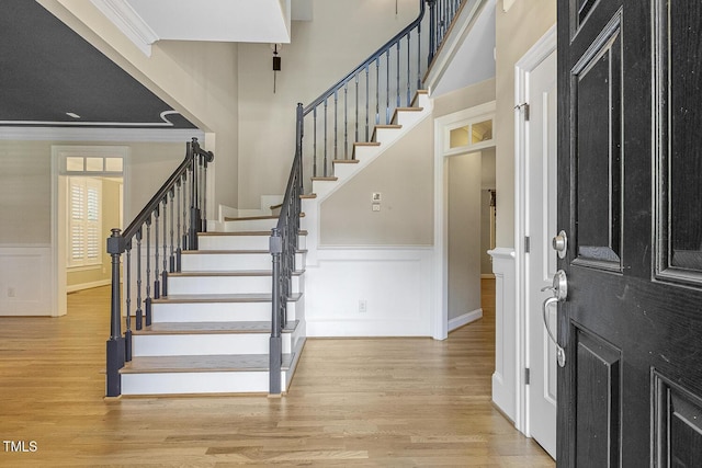 3124 Briar Stream Run, Raleigh, NC 27612 - foyer featuring stairs, wood finished floors, crown molding, a wainscoted wall, and a decorative wall