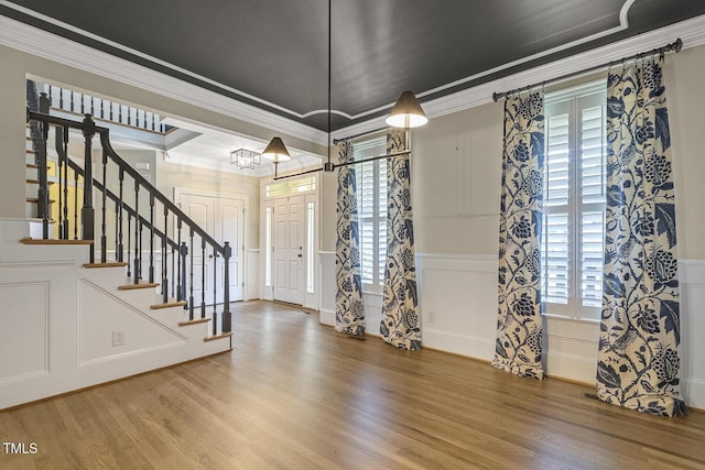 3124 Briar Stream Run, Raleigh, NC 27612 - entrance foyer with wood finished floors, crown molding, a decorative wall, stairs, and a wainscoted wall