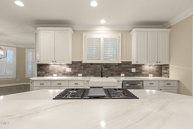 3124 Briar Stream Run, Raleigh, NC 27612 - kitchen featuring a sink, crown molding, white cabinets, light stone countertops, and backsplash