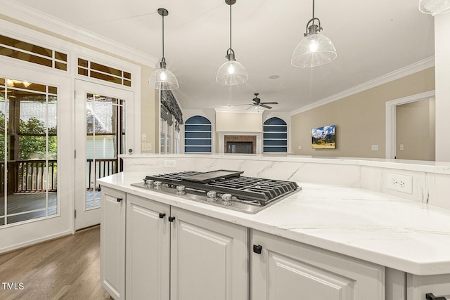 3124 Briar Stream Run, Raleigh, NC 27612 - kitchen with stainless steel gas stovetop, ornamental molding, wood finished floors, a ceiling fan, and white cabinets