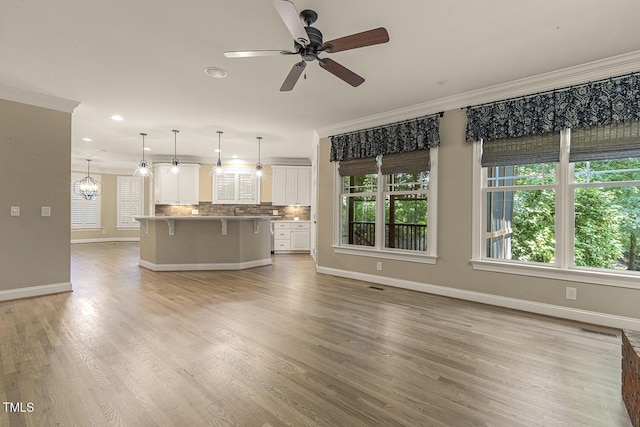 3124 Briar Stream Run, Raleigh, NC 27612 - unfurnished living room with baseboards, a ceiling fan, crown molding, light wood finished floors, and recessed lighting
