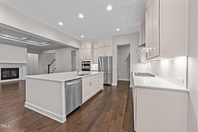 7502 Latteri Ct, Raleigh, NC 27613 - kitchen with stainless steel appliances, dark wood-type flooring, recessed lighting, a kitchen island with sink, and white cabinets