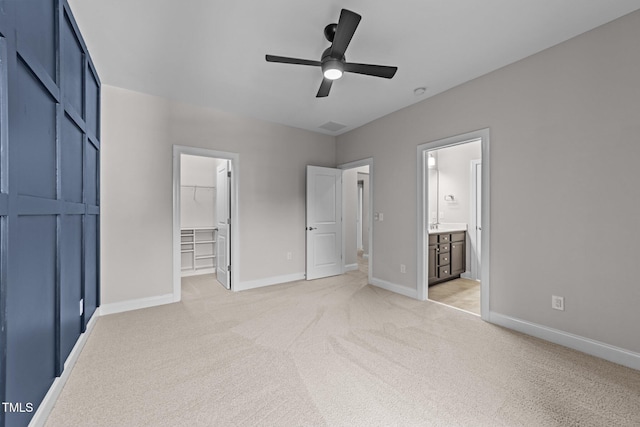 7502 Latteri Ct, Raleigh, NC 27613 - unfurnished bedroom featuring a walk in closet, light colored carpet, a closet, connected bathroom, and ceiling fan