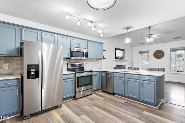 50 Rainwood Ct, Louisburg, NC 27549 - kitchen featuring stainless steel appliances, a sink, a peninsula, blue cabinetry, and light countertops