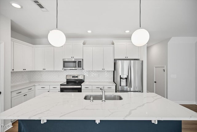 214 George Pine Way, Knightdale, NC 27545 - kitchen featuring stainless steel appliances, a sink, a large island with sink, tasteful backsplash, and white cabinetry