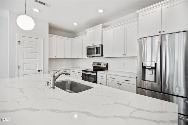 214 George Pine Way, Knightdale, NC 27545 - kitchen with stainless steel appliances, a sink, tasteful backsplash, white cabinetry, and pendant lighting