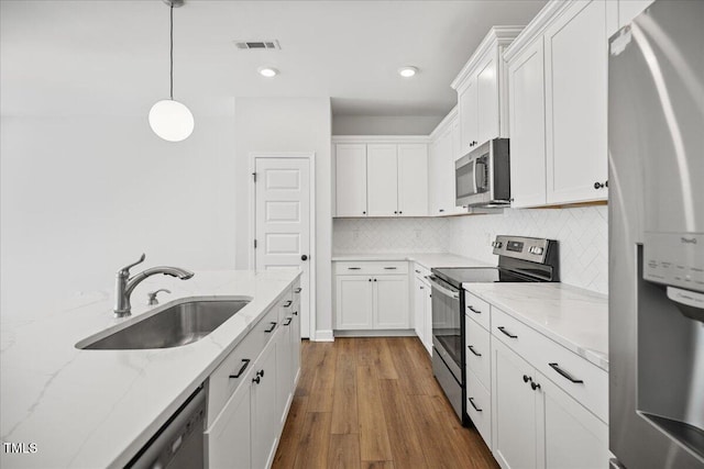 214 George Pine Way, Knightdale, NC 27545 - kitchen featuring appliances with stainless steel finishes, a sink, white cabinetry, wood finished floors, and recessed lighting