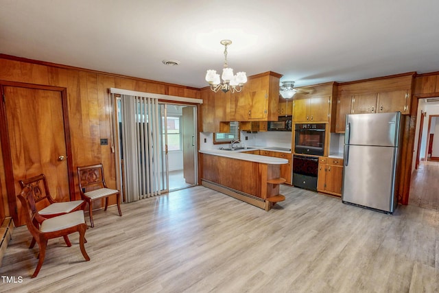 9455 Boston Rd, Roxboro, NC 27574 - kitchen with black appliances, a sink, brown cabinets, light countertops, and a chandelier