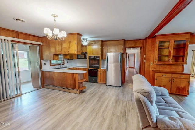 9455 Boston Rd, Roxboro, NC 27574 - kitchen with black appliances, a peninsula, open floor plan, brown cabinetry, and a sink