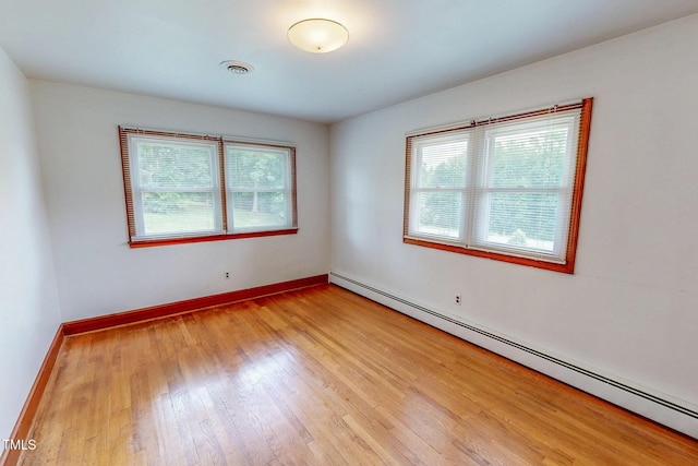 9455 Boston Rd, Roxboro, NC 27574 - spare room with a baseboard heating unit, light wood-style floors, and baseboards