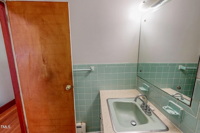 9455 Boston Rd, Roxboro, NC 27574 - bathroom with a baseboard radiator, tile walls, a sink, and wainscoting