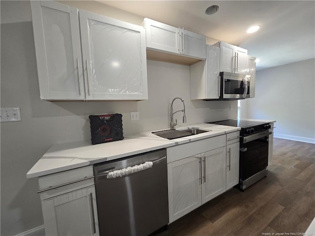 409 Thimbleberry Dr, Vass, NC 28394 - kitchen with stainless steel appliances, a sink, dark wood-type flooring, baseboards, and white cabinetry