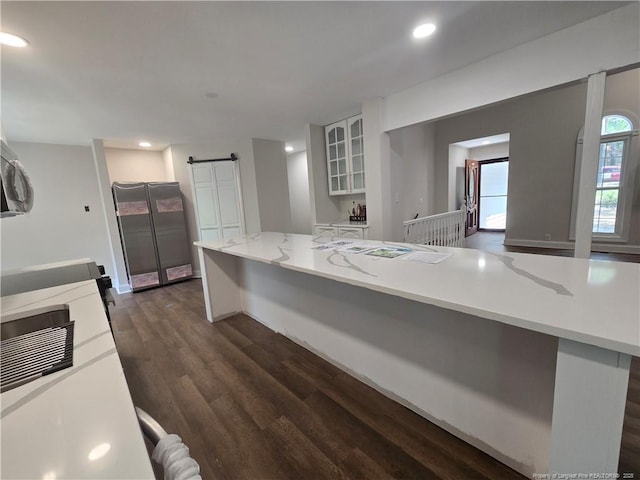 409 Thimbleberry Dr, Vass, NC 28394 - kitchen featuring a barn door, dark wood-style flooring, white cabinetry, glass insert cabinets, and recessed lighting