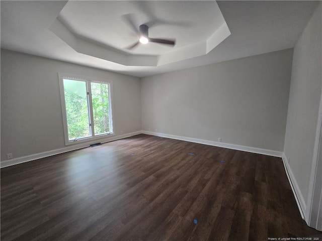 409 Thimbleberry Dr, Vass, NC 28394 - spare room featuring a tray ceiling, a ceiling fan, dark wood-style flooring, and baseboards