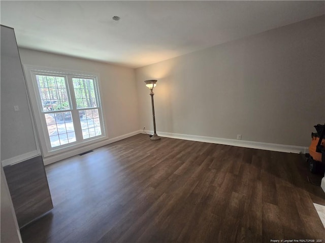 409 Thimbleberry Dr, Vass, NC 28394 - unfurnished living room with dark wood-type flooring and baseboards