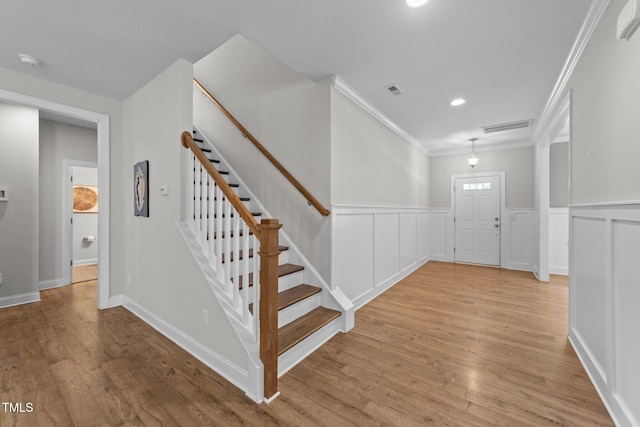 516 Culmore Dr, Fuquay Varina, NC 27526 - foyer entrance with crown molding, stairs, light wood-style flooring, recessed lighting, and wainscoting