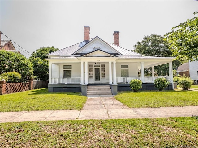 1206 Elm St N, Lumberton, NC 28358 - view of front of house featuring a porch, a front lawn, a chimney, and metal roof
