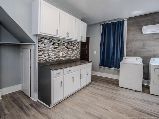1206 Elm St N, Lumberton, NC 28358 - laundry area with washing machine and clothes dryer, a wall mounted AC, light wood finished floors, and baseboards